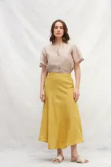 Falda midi color mostaza, de lino, con corte evasé y cintura alta.
