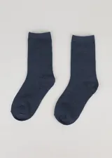 Par de medias blancas de media caña, lisas, ideales para uso escolar.