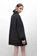 Remerón negro oversize con cuello camisero gris, mangas largas grises con puños elásticos, bolsillo con tapa en el pecho y logo bordado.