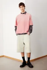 Remera rosa con efecto desteñido, corte amplio, cuello redondo y mangas cortas.