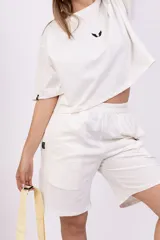 Remera blanca de corte holgado con logo pequeño bordado en negro en el pecho.