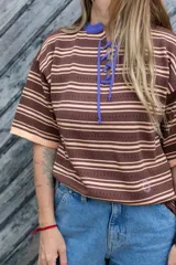 Camiseta manga corta tejida en hilo de algodón, con calado sutil en el cuerpo y escote acordonado.