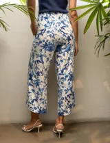Pantalón capri estampado con flores en tonos celeste, blanco y negro. Tiene pretina elastizada en la parte trasera y bolsillos delanteros.