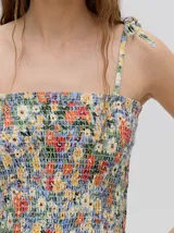 Top corto negro con textura fruncida, tirantes finos con lazos ajustables y corte crop.