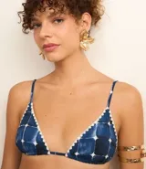 Top de bikini triangular con estampado de azulejos azules y blancos, breteles finos ajustables y detalle de volados en los bordes.