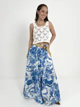 Falda larga de algodón con estampado floral en tonos azul y blanco. Tiene cintura elástica y cinto de rafia elastizado desmontable.