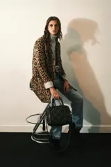Tapado de paño con estampado animal print, de calce recto y solapas angostas. Tiene botones al frente y bolsillos ojal.