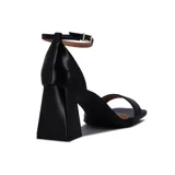 Sandalia de tacón alto color blanco, con una tira delgada sobre los dedos y pulsera con hebilla al tobillo.