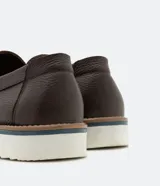 Zapato slip on marrón de cuero con suela blanca.
