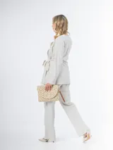 Conjunto color beige de lino, compuesto por un blazer cruzado con lazo para atar y un pantalón de corte recto con cintura elástica.