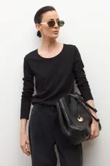 Remera de manga larga color negro, con escote redondo amplio.