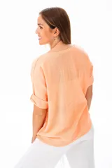 Blusa color coral claro de viscosa con escote redondo y mangas cortas con dobladillo.