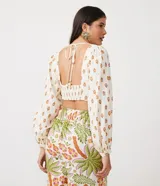 Blusa cropped de lino con escote corazón, lazada en la espalda, manga larga abullonada y estampado de anacardos.