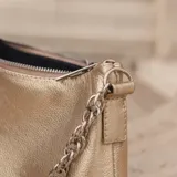 Cartera tipo baguette de cuero color rojo brillante, con correa de cadena plateada.