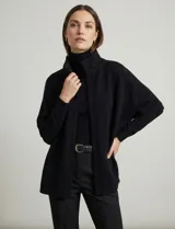 Capa tejida color fucsia, con cuello alto abotonado y mangas cortas estilo japonesa. Tejido de punto grueso.