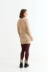 Vestido corto de tejido de punto color beige, manga larga y cuello polo con escote en V.