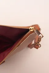 Sobre de algodón a rayas verticales de colores naranja, rosa, marrón, rojo y blanco. Tiene cierre superior con cremallera y tira de cuero marrón para la muñeca.