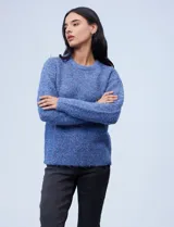 Buzo de tejido melange color beige con puntos oscuros, cuello redondo y manga larga.