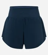 Bermuda deportiva femenina de microfibra color amarillo claro, con diseño de doble capa: un short interno ajustado y una capa externa suelta con bajo redondeado. Posee cintura alta.