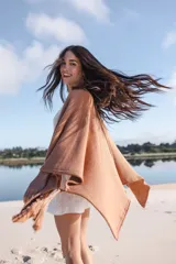 Saco tipo poncho color salmón, tejido en algodón, de silueta oversize y mangas 3/4 caídas.