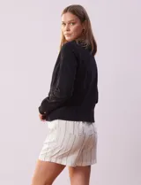 Campera de algodón negra, marca Baccini, con abertura central con cierre y bolsillos delanteros.