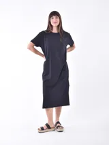 Vestido negro de corte recto, largo midi y mangas cortas.