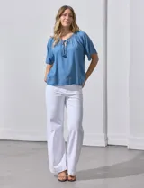 Blusa celeste de lyocell con escote en V, punto smock y lazo de ajuste.
