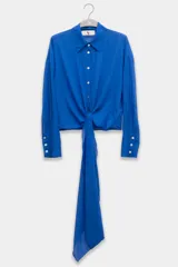 Camisa azul de manga larga con lazo en la cintura y botones nacarados.