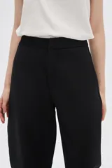 Pantalón blanco de poliéster, corte ancho, tiro alto y bolsillos laterales.