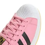 Zapatillas Adidas Superstar edición especial Messi, color rosa con las tres tiras laterales en negro y detalles en blanco en la puntera y la suela.