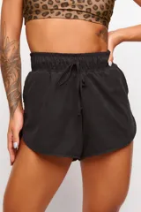 Short deportivo negro de tejido suave con elástico en la cintura y cordón ajustable.