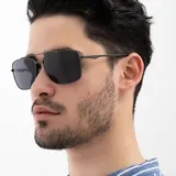 Lentes de sol INVU con montura metálica color gris plomo, forma cuadrada y lentes polarizadas grises.