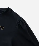 Remera negra de algodón con cuello redondo, mangas cortas abullonadas y apliques flocados con diseño de leopardo.