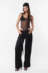 Body negro tipo lencero de microtul con breteles elásticos dobles de ajuste regulable. Corpiño de encaje que pasa por debajo del body con avío de encastre en delantero. Elástico en todas sus terminaciones y en interior de tiro para mejor ajuste de la prenda al cuerpo, para facilitar acceso, botones a presión snap en entrepierna.