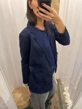 Blazer beige de tela agamusada, corte clásico, con solapas y bolsillo de parche.