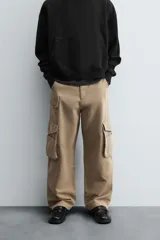 Pantalón cargo color beige, de corte relaxed fit, con bolsillos frontales, traseros con solapa y bolsillos laterales tipo parche con solapa.
