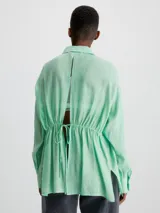 Camisa de rayón arrugado color verde, con cuello en punta, manga larga y detalle anudado en la espalda.
