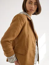 Blazer color mostaza de lino con corte estructurado, solapas con pespuntes y bolsillos con solapa.