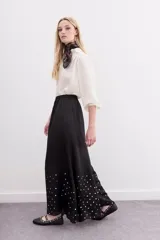 Pantalón amplio de viscosa color negro, con caída fluida, cintura elastizada y lentejuelas en la botamanga.