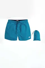 Short de baño para hombre, color turquesa con estampado de puntos en tono azul oscuro. Posee cintura elástica con cordón de ajuste y viene con una bolsa de guardado a juego.