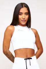 Top deportivo blanco de corte cropped, con cuello alto y logo estampado en el frente.
