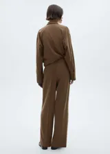 Pantalón de vestir marrón con finas rayas verticales, corte wideleg, tiro alto, bolsillos laterales y cierre frontal oculto.