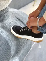 Zapatillas deportivas color negro, con detalles en cuero y suela de goma.