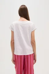 Remera blanca de algodón con apliques de encaje en los hombros, corte holgado y cuello redondo.