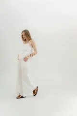 Pantalón palazzo de lino color blanco, tiro medio, con bolsillos delanteros y placa en la espalda.