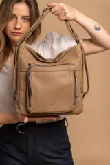 Cartera mochila color marrón de símil cuero suave con múltiples bolsillos con cierre, división al medio y correa ajustable de doble manija para llevar al hombro y como mochila.