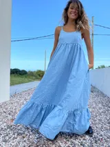 Maxi vestido celeste de jean con breteles regulables y bolsillos laterales.