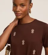 Blusa marrón de mangas cortas, confeccionada en viscosa, con cuello redondo y bordados de piñas en la parte delantera.