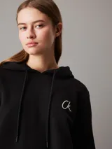 Buzo negro de felpa de algodón con capucha y cordón ajustable. Logo de Calvin Klein bordado en blanco en el pecho.