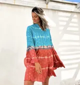 Vestido camisero corto con estampado batik en tonos turquesa y terracota con detalles dorados, cuello mao y mangas 3/4 acampanadas.